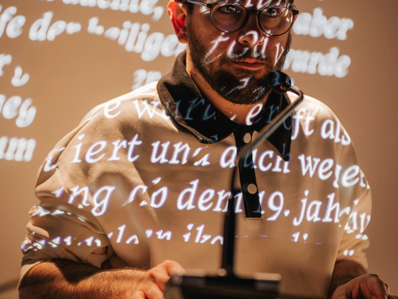 an/grenzen: Ausnahmezustand! Ein Lyrikspektakel, April 2024 im Literaturhaus Göttingen. <br/>Giorgio Ferretti bei seiner Lesung mit Quang Nguyen: „Bugs and Arrows”. Eine typographische Performance.