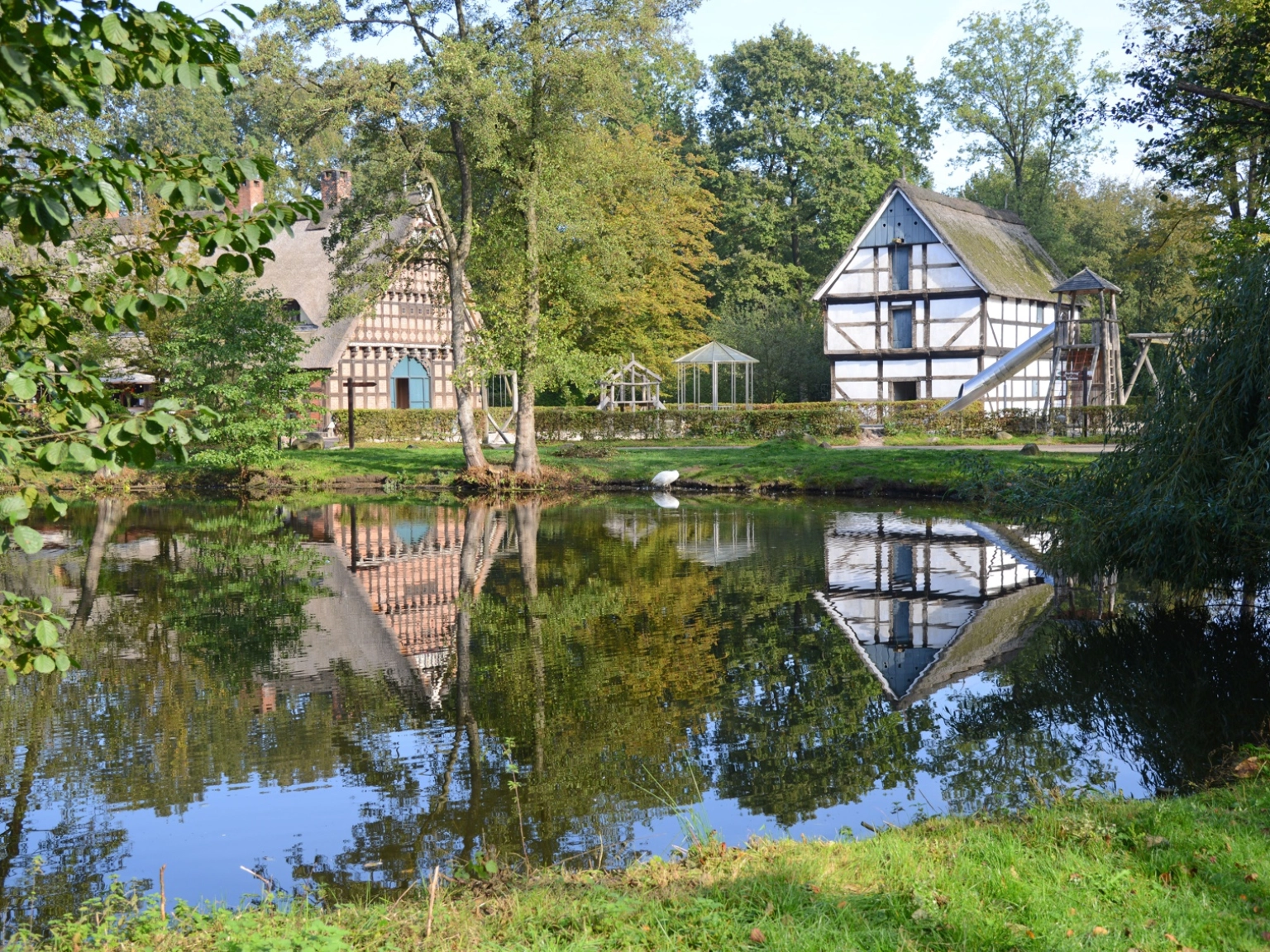 Impression des Museumsdorfs Cloppenburg. Zu sehen sind der Teich mit Dorfkrug und Speicher