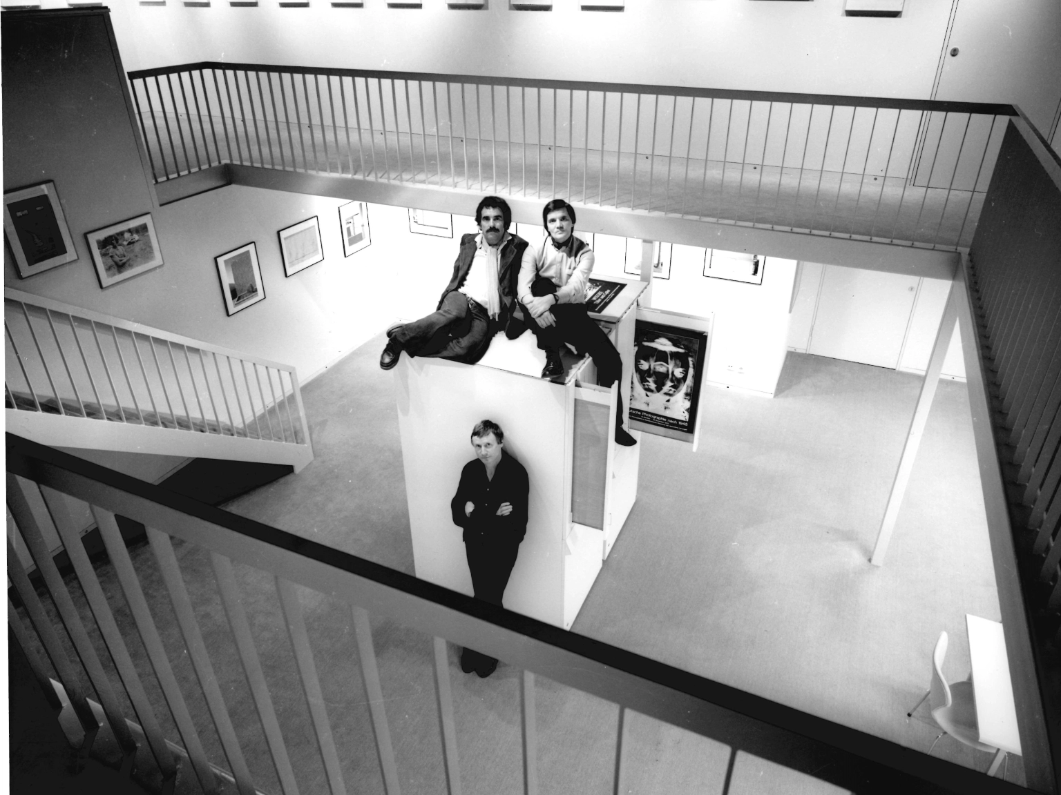 Der zweigeschossige Ausstellungsraum der Spectrum Photogalerie im Untergeschoss des Sprengel Museum Hannover (1979-1991): Peter Gauditz (stehend), Joachim Giesel (links) und Heinrich Riebesehl, 1979. 