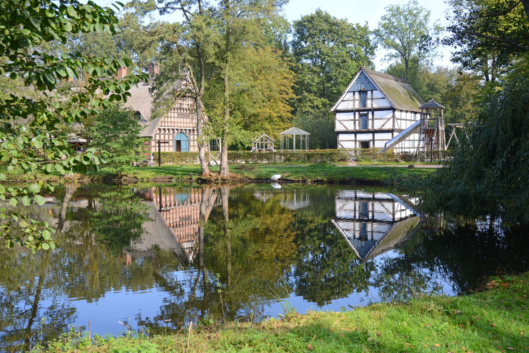 Impression des Museumsdorfs Cloppenburg. Zu sehen sind der Teich mit Dorfkrug und Speicher