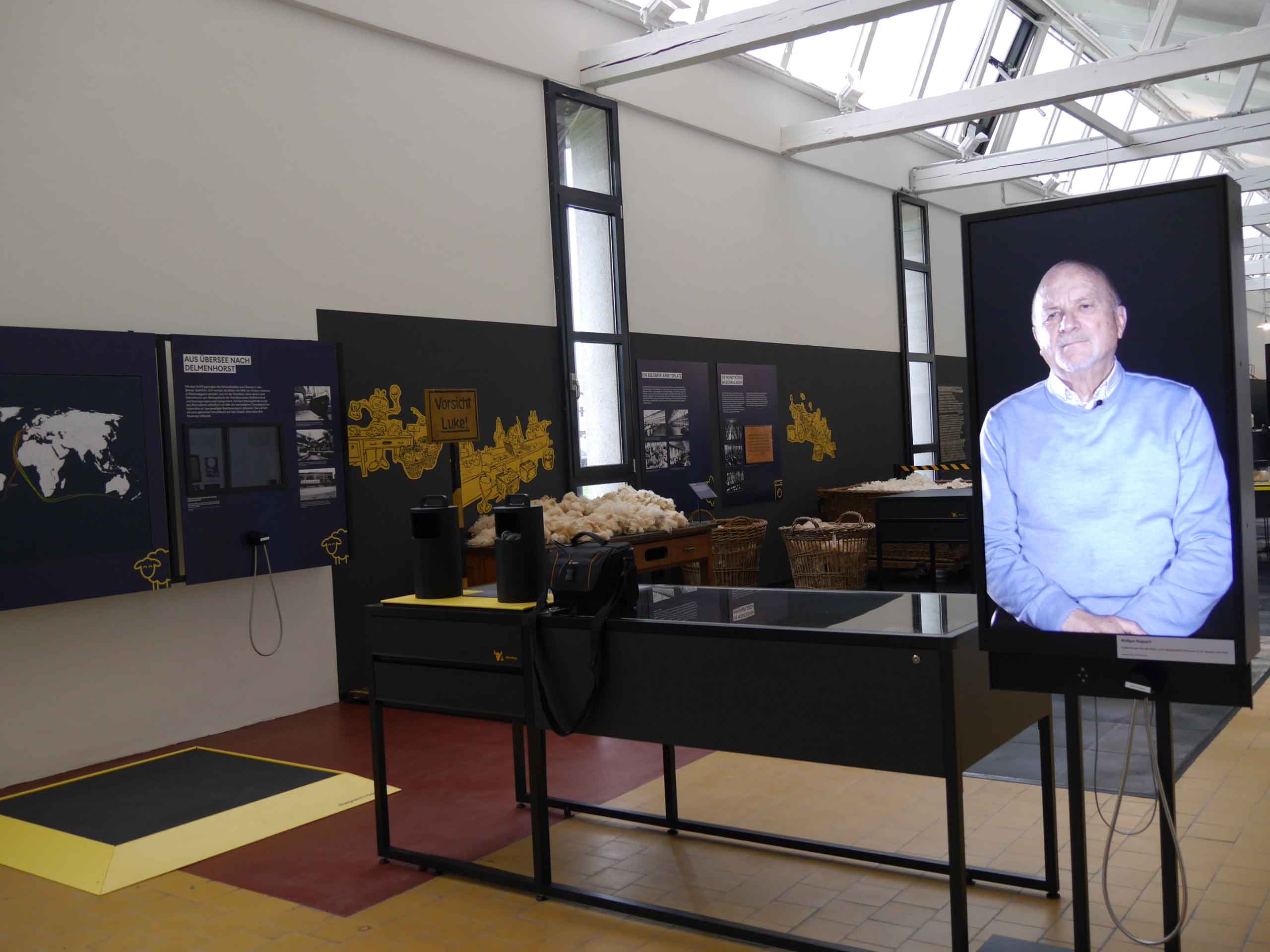Impression der Dauerausstellung im Fabrikmuseum Delmenhorst: Ehemalige Mitarbeiter*innen der Nordwolle geben in Filmen Einblicke