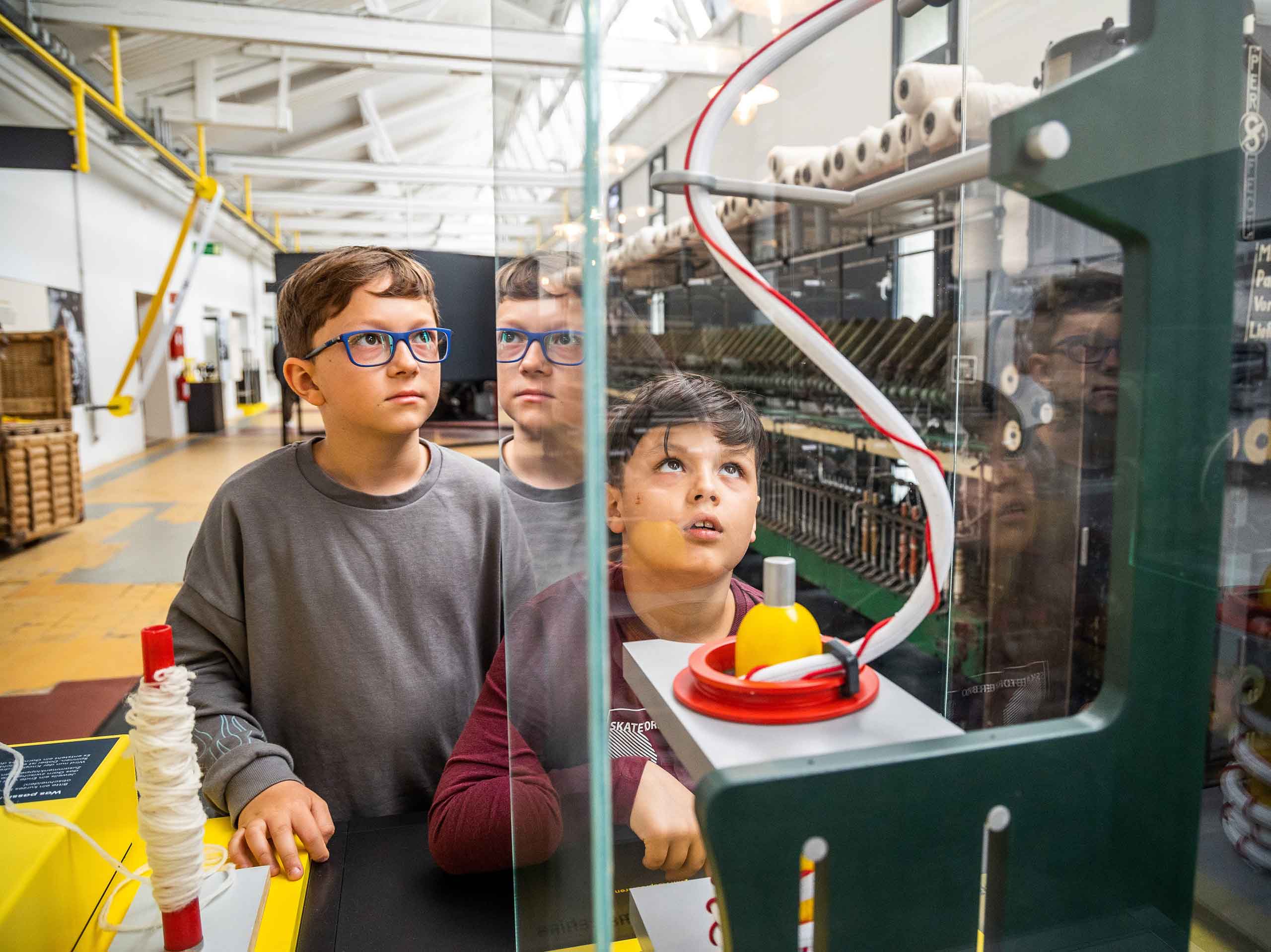 Impression der Dauerausstellung im Fabrikmuseum Delmenhorst: Kinder entdecken die Kammgarnproduktion
